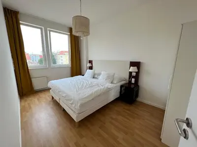 a bedroom with a white bed and two windows at Holiday home Prague in Prague