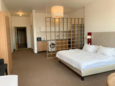 a bedroom with a large white bed and a kitchen at Holiday home Prague in Prague