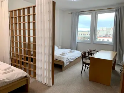 a room with two beds and a desk and a table at Holiday home Prague in Prague