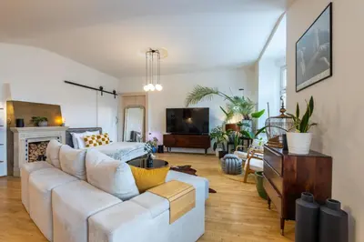 a living room with a white couch and a tv at Apartment Ruska in Prague