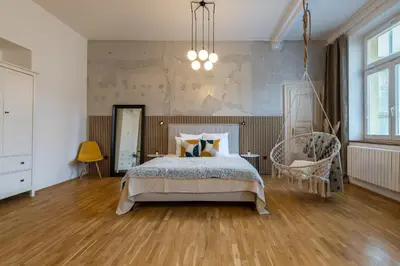 a bedroom with a bed and a chair in it at Apartment Ruska in Prague