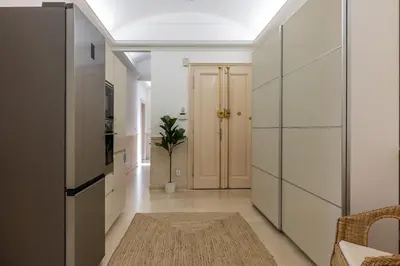 a hallway with white cabinets and a potted plant at Apartment Ruska in Prague