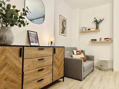 a living room with a dresser and a chair at NiceLovely & Prague Apartment Dlouha in Prague