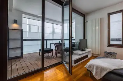 a room with a balcony with a television and a bedroom at Modern spacious flat with a terrace and a parking in Prague