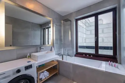 a bathroom with a sink and a washing machine at Modern spacious flat with a terrace and a parking in Prague