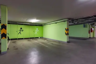 an empty parking garage with green paint on the walls at Modern spacious flat with a terrace and a parking in Prague