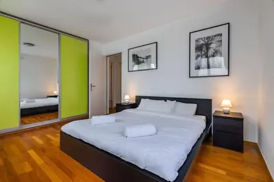 a large bedroom with a large bed with two lamps at Modern spacious flat with a terrace and a parking in Prague