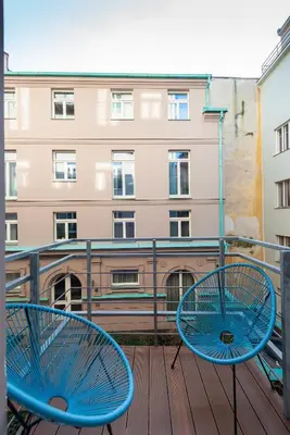 two blue chairs on a balcony with a building at Prague Spirit in Prague