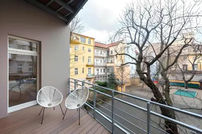 a balcony with two chairs and a tree at Prague Spirit in Prague
