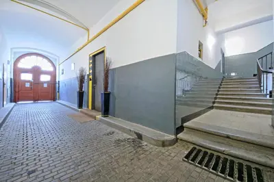 an empty hallway with a red door and stairs at Rose Antique Apartment in Prague
