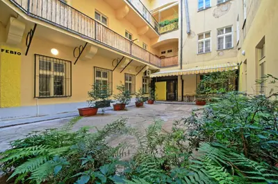 an empty courtyard of a building with potted plants at Rose Antique Apartment in Prague
