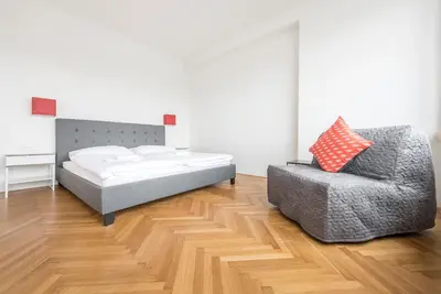 a bedroom with a bed and a chair at Merkur apartments in Prague