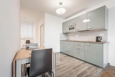 a kitchen with a wooden table and a desk at Merkur apartments in Prague