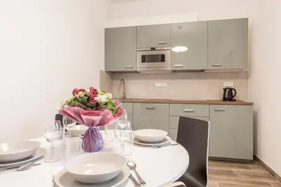 a kitchen with a table with a vase of flowers on it at Merkur apartments in Prague