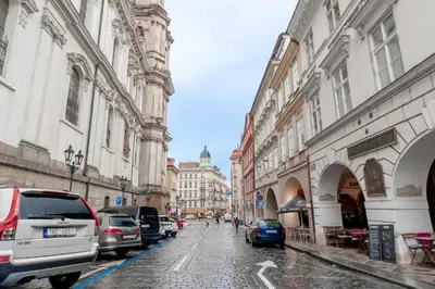 a city street with parked cars and buildings at Charming Apartment in Lesser Town in Prague