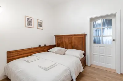 a bedroom with a large bed with a wooden headboard at Charming Apartment in Lesser Town in Prague