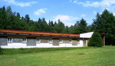 a building with a grass field in front of it at Sport areál Samopše in Vraník