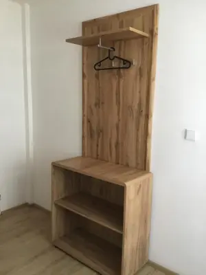 a wooden book shelf in a corner of a room at Hrusická restaurace a penzion in Hrusice