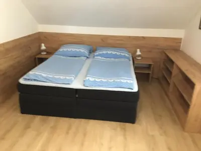 two twin beds in a room with wooden floors at Hrusická restaurace a penzion in Hrusice