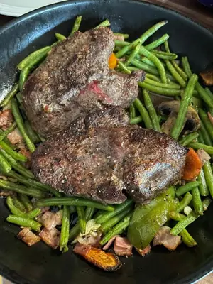 a plate of food with meat and green beans at Hrusická restaurace a penzion in Hrusice