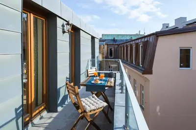 a balcony with a table and chairs on a building at Modern Apartment Charvatova in Prague