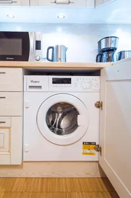 a kitchen with a washing machine and a microwave at Modern Apartment Charvatova in Prague
