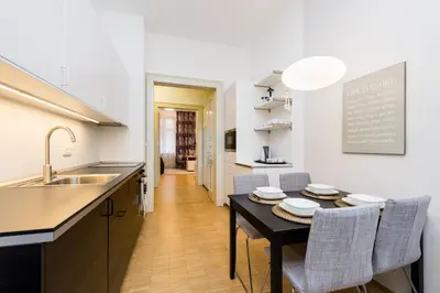 a kitchen with a table and chairs and a sink at Modern Apartment Charvatova in Prague
