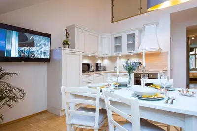a kitchen with a white table and white chairs at Modern Apartment Charvatova in Prague