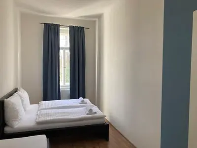 a white bed in a room with a window at Erbenova Apartments in Prague
