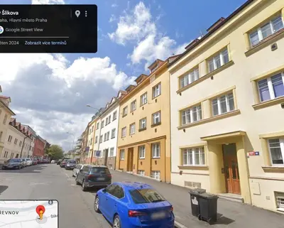a blue car parked on a street next to buildings at Flat white flat in Prague