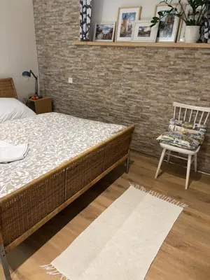 a bedroom with a bed and a chair and a brick wall at Flat white flat in Prague