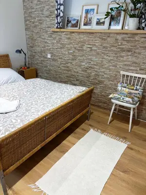a bedroom with a bed and a chair and a brick wall at Flat white flat in Prague