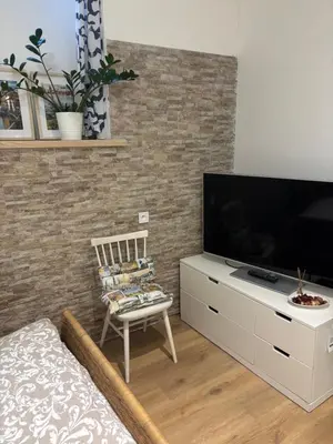 a living room with a television and a chair at Flat white flat in Prague