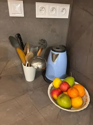 a bowl of fruit on a counter next to a juicer at Flat white flat in Prague