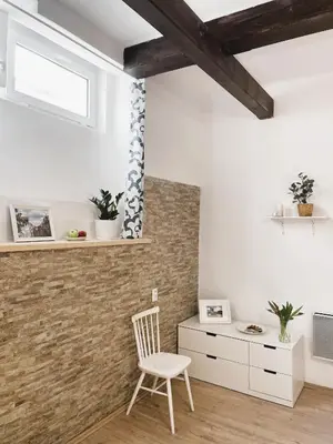 a room with a white chair and a brick wall at Flat white flat in Prague