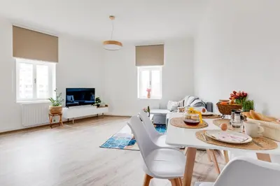 a white living room with a table and chairs at Modern, bright and spacious apartment in Prague