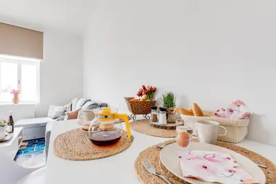 a living room with white walls and rattan baskets at Modern, bright and spacious apartment in Prague