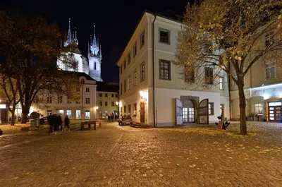 a city street at night with a building with a clock tower at Women's Only Hostel - Female Only in Prague