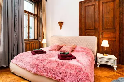 a bedroom with a pink bed with a pink blanket at Imperial Deluxe Suite in Prague