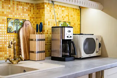 a kitchen counter with a microwave and a sink at Imperial Deluxe Suite in Prague