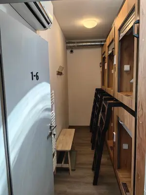 a room with stairs and a table and a door at Capsule hostel Erbenova in Prague