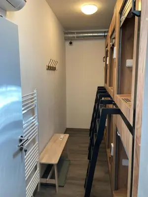 a small room with a table and a stairway at Capsule hostel Erbenova in Prague