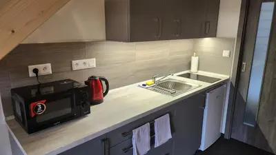 a small kitchen with a microwave and a sink at Penzion-Dubno in Dubno