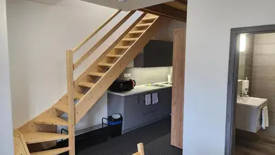 a wooden staircase in a room with a kitchen at Penzion-Dubno in Dubno