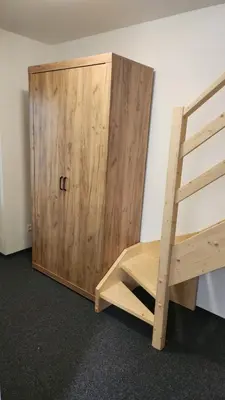 a wooden bunk bed next to a wooden cabinet at Penzion-Dubno in Dubno