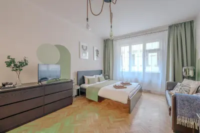 a hotel room with a bed and a tv at Cozy Prague Apartment in Prague