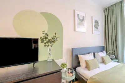 a bedroom with a bed and a desk and a television at Cozy Prague Apartment in Prague
