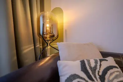 a lamp sitting next to a couch with a pillow at Cozy Prague Apartment in Prague