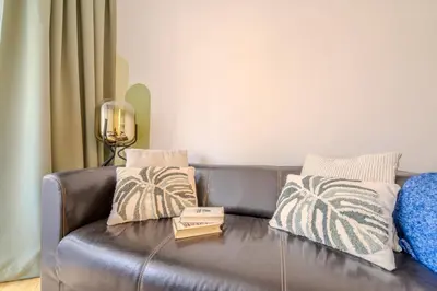 a brown leather couch with two pillows on it at Cozy Prague Apartment in Prague