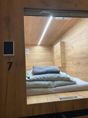 a mirror reflection of a bed in a room at Capsule hostel Žižkov tower in Prague